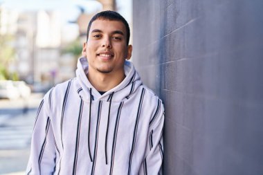 Sokakta kendine güvenen genç adam gülümsüyor