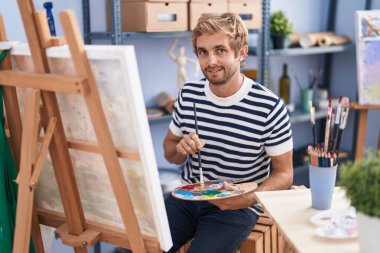 Young man artist smiling confident drawing at art studio