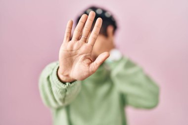 Young beautiful woman standing over pink background covering eyes with hands and doing stop gesture with sad and fear expression. embarrassed and negative concept. 