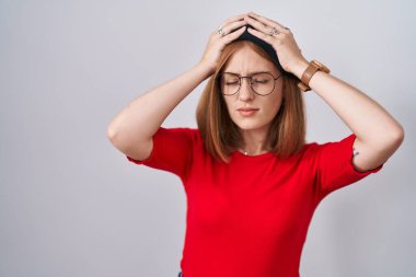 Genç kızıl saçlı, gözlüklü, bereli, baş ağrısı çeken çaresiz ve stresli bir kadın. Ağrı ve migren yüzünden. Eller başının üstünde.. 