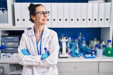 Young caucasian woman scientist smiling confident standing with arms crossed gesture at laboratory