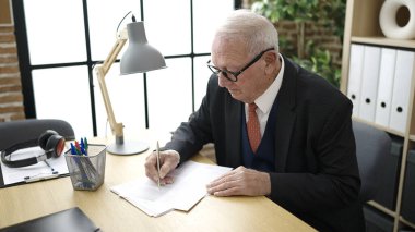 Ofisteki belgelere yazı yazan üst düzey bir iş adamı