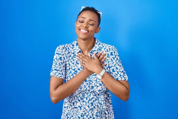 African American Woman Standing Blue Background Smiling Hands Chest Closed — Stock fotografie