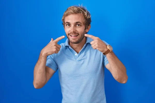 Hombre Caucásico Pie Sobre Fondo Azul Sonriendo Alegre Mostrando Señalando —  Fotos de Stock