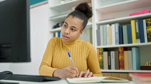 Νεαρή Αφρο Αμερικανίδα Φοιτήτρια Που Χρησιμοποιεί Υπολογιστή Κρατώντας Σημειώσεις Στη — Φωτογραφία Αρχείου