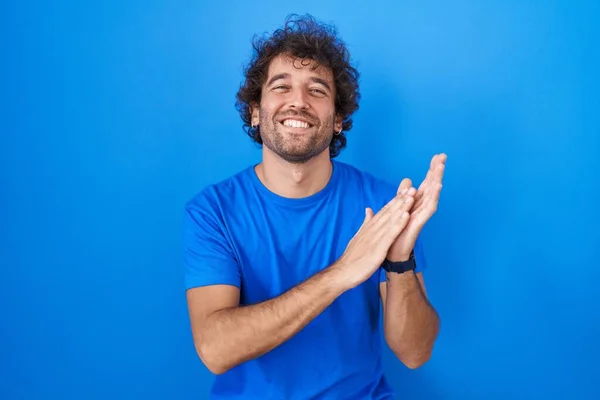 Ισπανόφωνος Νεαρός Που Στέκεται Πάνω Από Μπλε Φόντο Χειροκροτώντας Χαρούμενα — Φωτογραφία Αρχείου