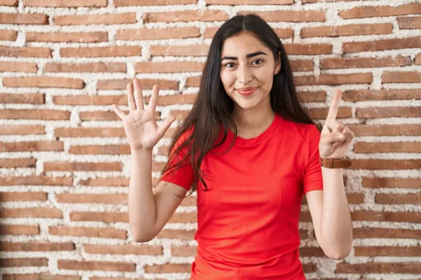 Junges Teenager Mädchen Steht Über Ziegelmauer Und Zeigt Mit Finger — Stockfoto