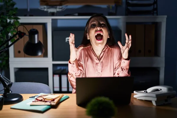 コンピュータのラップトップを使用して働いている中年のパニック女性は 深夜の狂気と怒鳴り声を上げ 積極的な表現と腕を上げて叫びました フラストレーションコンセプト — ストック写真