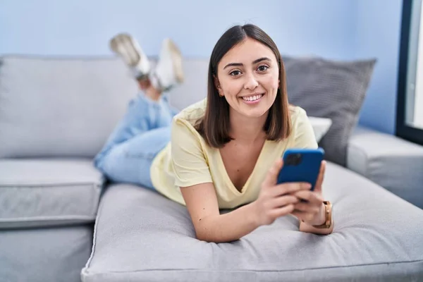Young Hispanic Woman Using Smartphone Lying Sofa Home — Stock Photo, Image