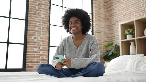 Afrikansk Amerikansk Kvinna Använder Smartphone Sitter Sängen Sovrummet — Stockfoto
