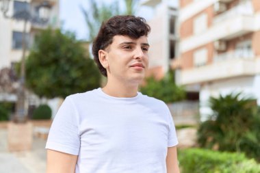 İkili olmayan adam parkta ciddi bir ifadeyle duruyor.