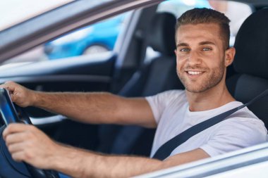 Sokakta kendine güvenen beyaz bir adam gülümsüyor.