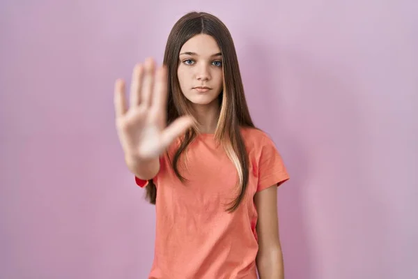 站在粉色背景上的少女停下手心唱歌 用消极而严肃的手势警告人 — 图库照片