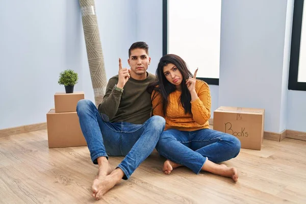Young Couple Sitting Floor New Home Pointing Looking Sad Upset — Stock Photo, Image