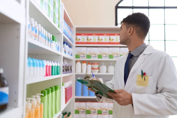 Young Hispanic Man Pharmacist Writing Clipboard Pharmacy — Stock fotografie