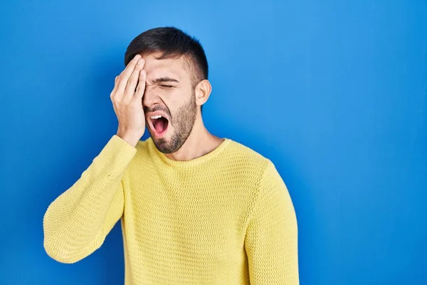 Hispanic Man Standing Blue Background Yawning Tired Covering Half Face — Stok fotoğraf