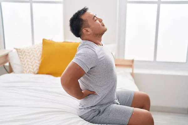 Junger Chinese Leidet Rückenverletzung Sitzt Schlafzimmer Auf Bett — Stockfoto