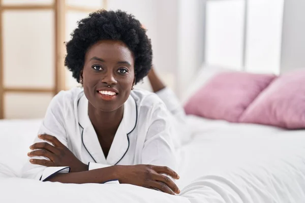 年轻的非洲女人笑着自信地躺在床上 躺在卧室里 — 图库照片