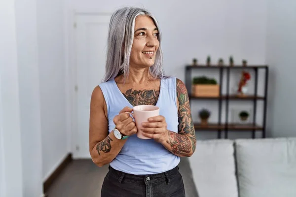 stock image Middle age grey-haired woman smiling confident drinking coffee at home