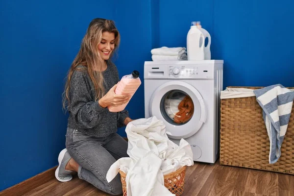 Genç Sarışın Kadın Gülümsüyor Çamaşır Odasında Elinde Yumuşatıcı Şişeyle Kendinden — Stok fotoğraf