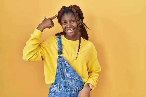 Afrikaanse Vrouw Staat Gele Achtergrond Glimlachend Wijzend Naar Hoofd Met — Stockfoto