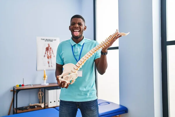 Африканский Американец Держащий Анатомическую Модель Высунутого Языка Довольный Смешным Выражением — стоковое фото