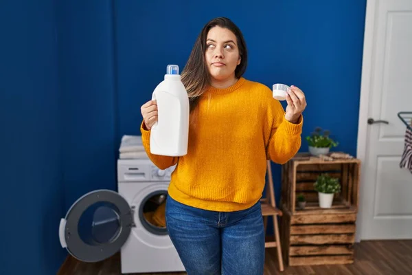 Young Hispanic Woman Holding Detergent Bottle Smiling Looking Side Staring — Stock Photo, Image