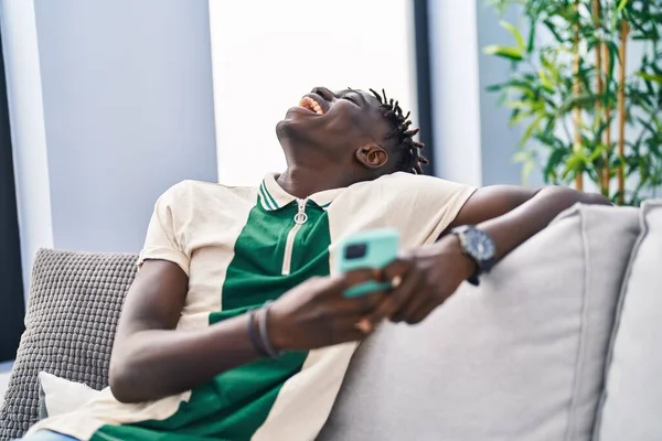 Afroamerikan Man Med Smartphone Sitter Soffan Hemma — Stockfoto