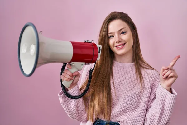 Young Caucasian Woman Shouting Megaphone Smiling Happy Pointing Hand Finger — Stockfoto
