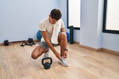 Spor merkezinde kendine güvenen genç İspanyol adam gülümsüyor.