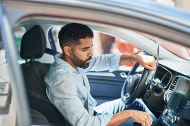 Arabasında oturan genç bir Arap sokakta radyoyu açıyor.