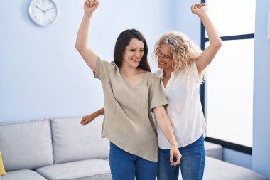 Two women mother and daughter dancing at home