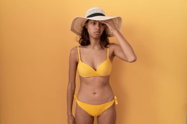 Genç İspanyol kadın bikini ve yaz şapkası takıyor. Alnındaki sorun yüzünden endişeli ve stresli. Kriz için endişeli. 