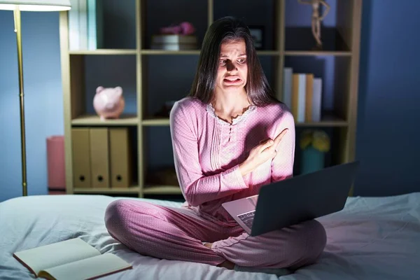 Young Hispanic Woman Using Computer Laptop Bed Pointing Aside Worried — Stock Photo, Image