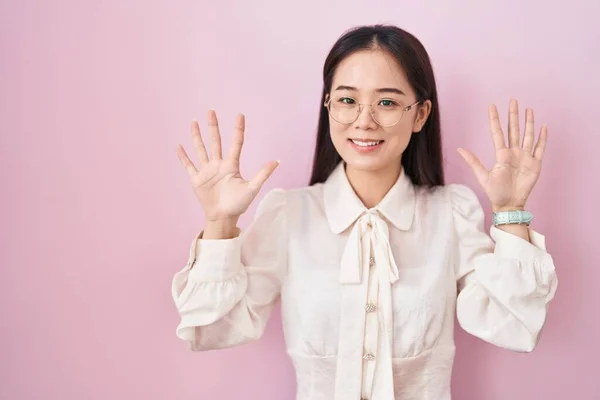 Mladá Číňanka Stojící Nad Růžovým Pozadím Ukazující Ukazující Prsty Číslo — Stock fotografie