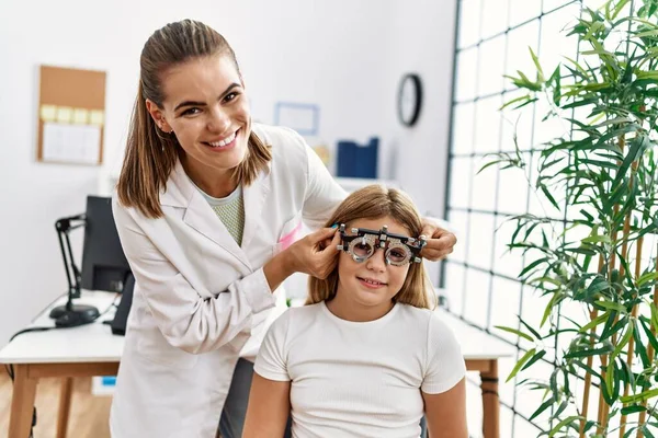 stock image Woman and girl oculist and patient examining vision using optometrist glasses at clinic