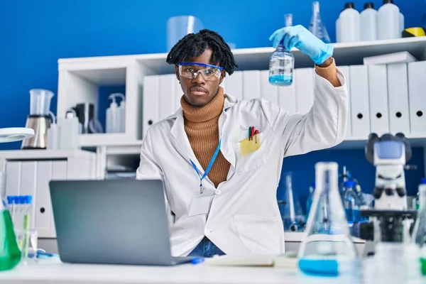 アフリカ系アメリカ人の科学者は実験室で液体を測定する — ストック写真