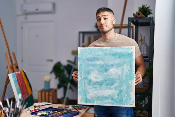 Jovem Pintor Hispânico Homem Segurando Tela Sorrindo Olhando Para Lado — Fotografia de Stock