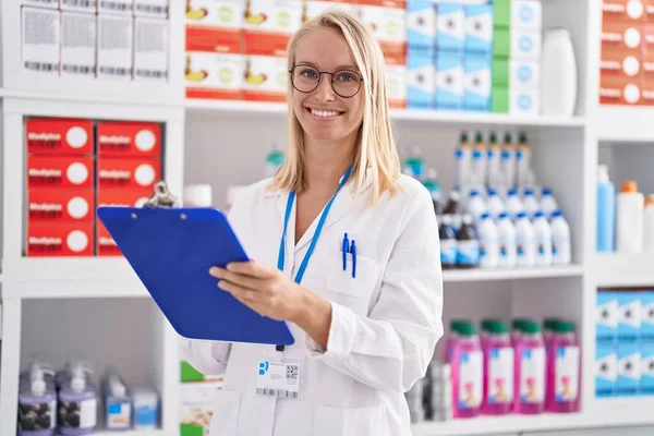 Young Blonde Woman Pharmacist Writing Document Pharmacy — Fotografia de Stock