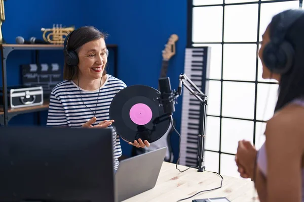 stock image Two women musicians listening to music holding vinyl disc at music studio