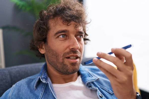 Young Hispanic Man Talking Smartphone Sitting Sofa Home — Stok fotoğraf