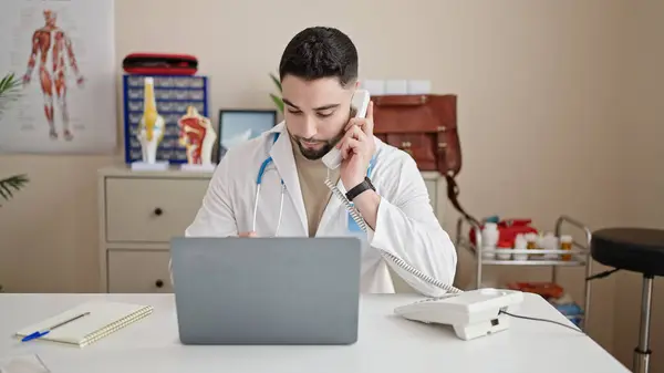 Giovane Arabo Uomo Medico Utilizzando Computer Portatile Parlando Telefono Clinica — Foto Stock