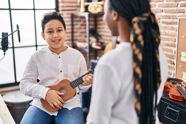 African american mother and son student learning play ukelele at music studio