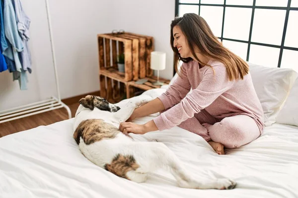 Joven Mujer Sonriendo Confiado Jugando Con Perro Sentado Cama Dormitorio —  Fotos de Stock
