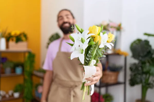 年轻的惊慌失措的花匠在花店里捧着一束花 — 图库照片