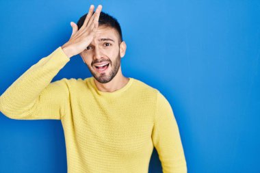 Mavi arka planda dikilen İspanyol adam, hata için el ele tutuşup şaşırdı, hatayı hatırla. Unuttum, kötü hafıza kavramı. 