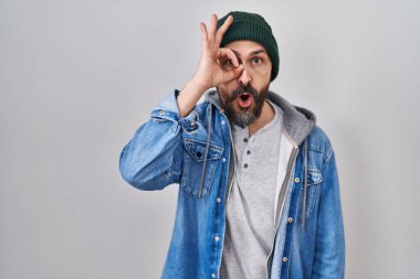 Yün şapkalı İspanyol genç adam şaşırmış yüz ifadesiyle şaşırmış, parmaklarından bakan bir jest yapıyor. İnançsız ifade. 