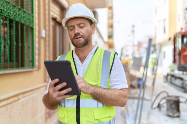 Middle age man architect using touchpad at street