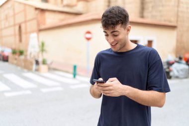 Sokakta akıllı telefon kullanan, kendine güvenen genç bir İspanyol.