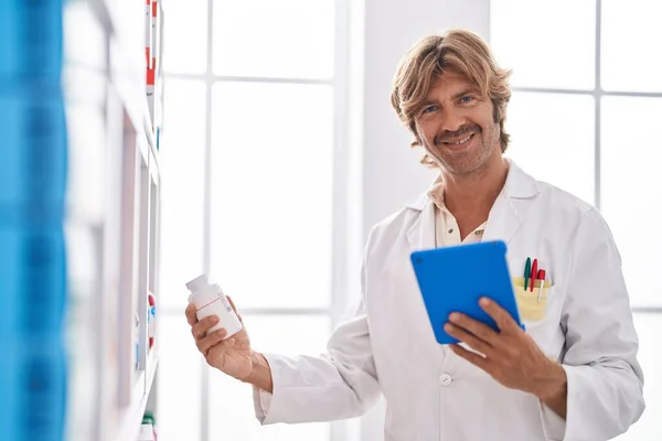 Hombre Joven Farmacéutico Sosteniendo Pastillas Botella Utilizando Touchpad Farmacia — Foto de Stock